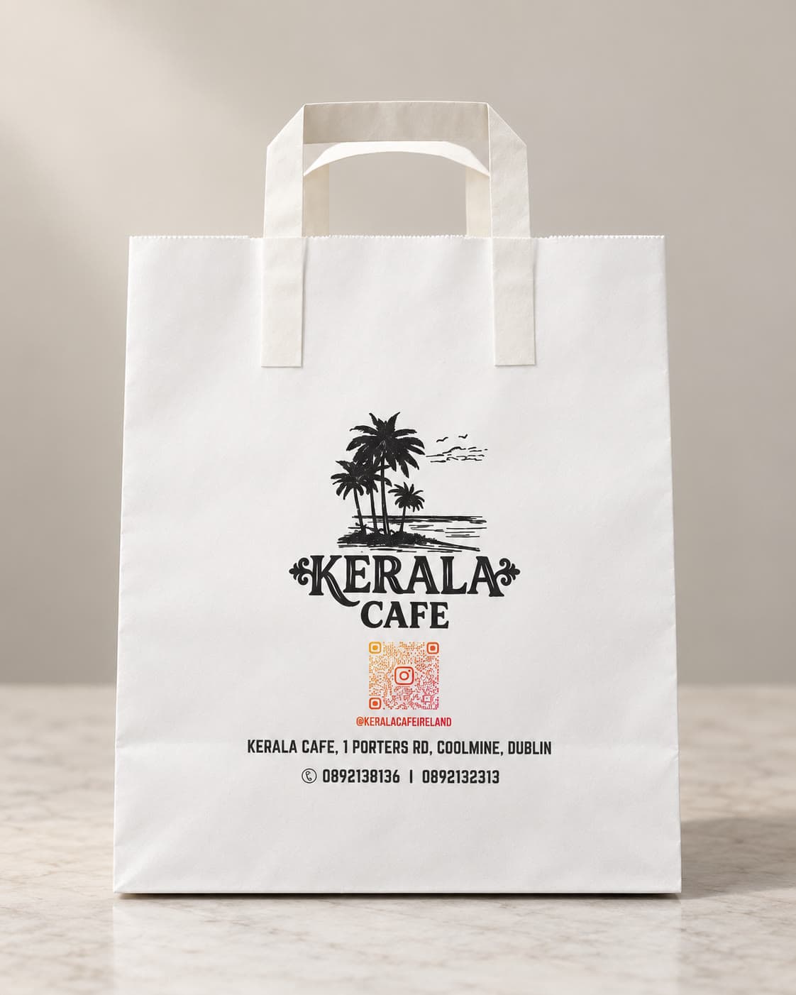 Kerala Cafe Coolmine Dublin — custom printed white paper bag with palm tree logo, Instagram QR code and takeaway contact details