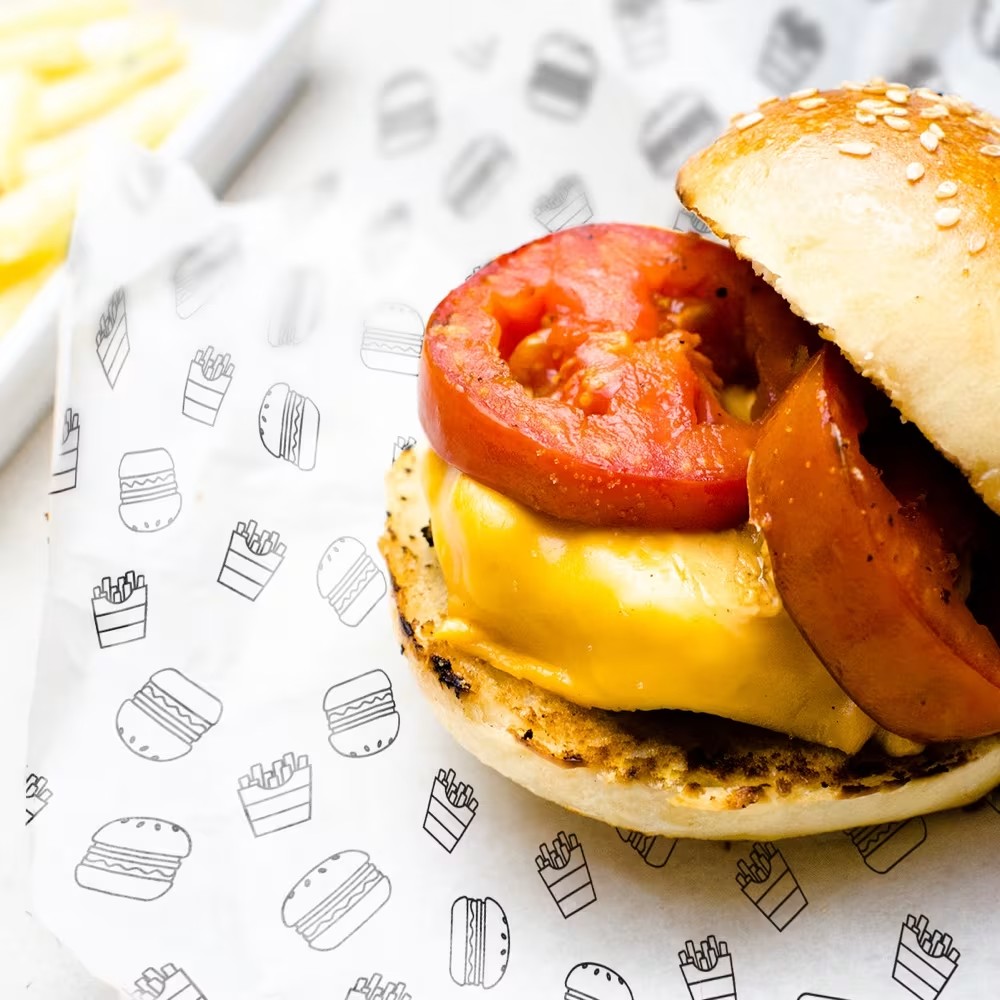 Printed greaseproof paper Ireland — custom pattern greaseproof sheet lining a burger tray in a restaurant